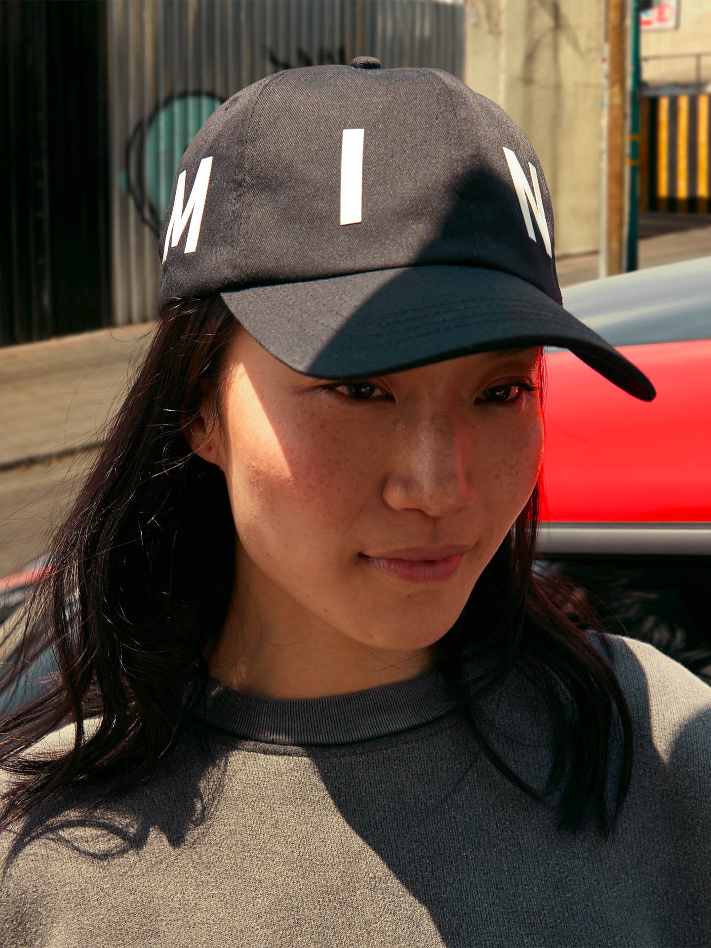 Female model wears a black MINI cap